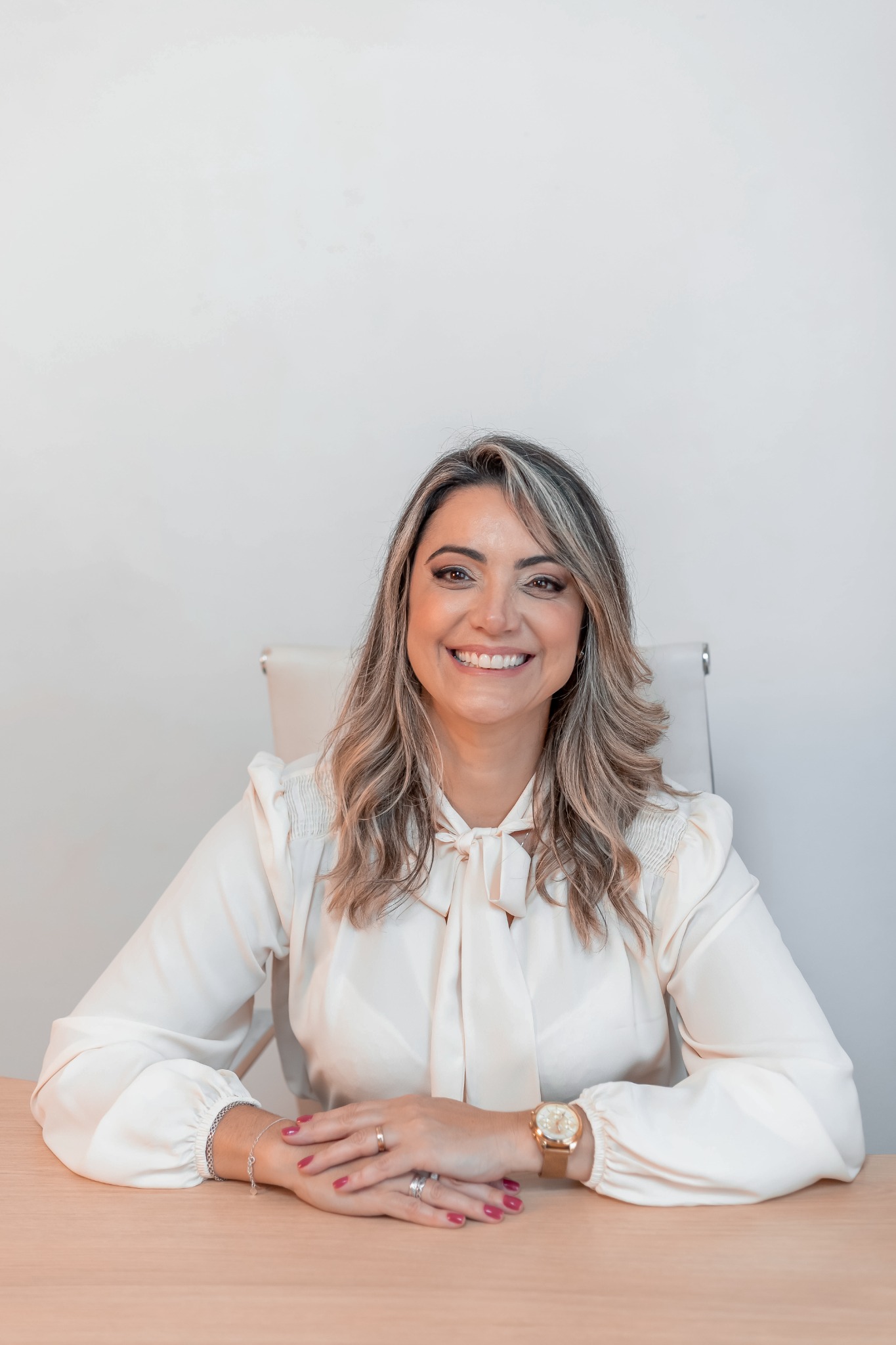 Etiene Soares sorrindo, sentada à mesa